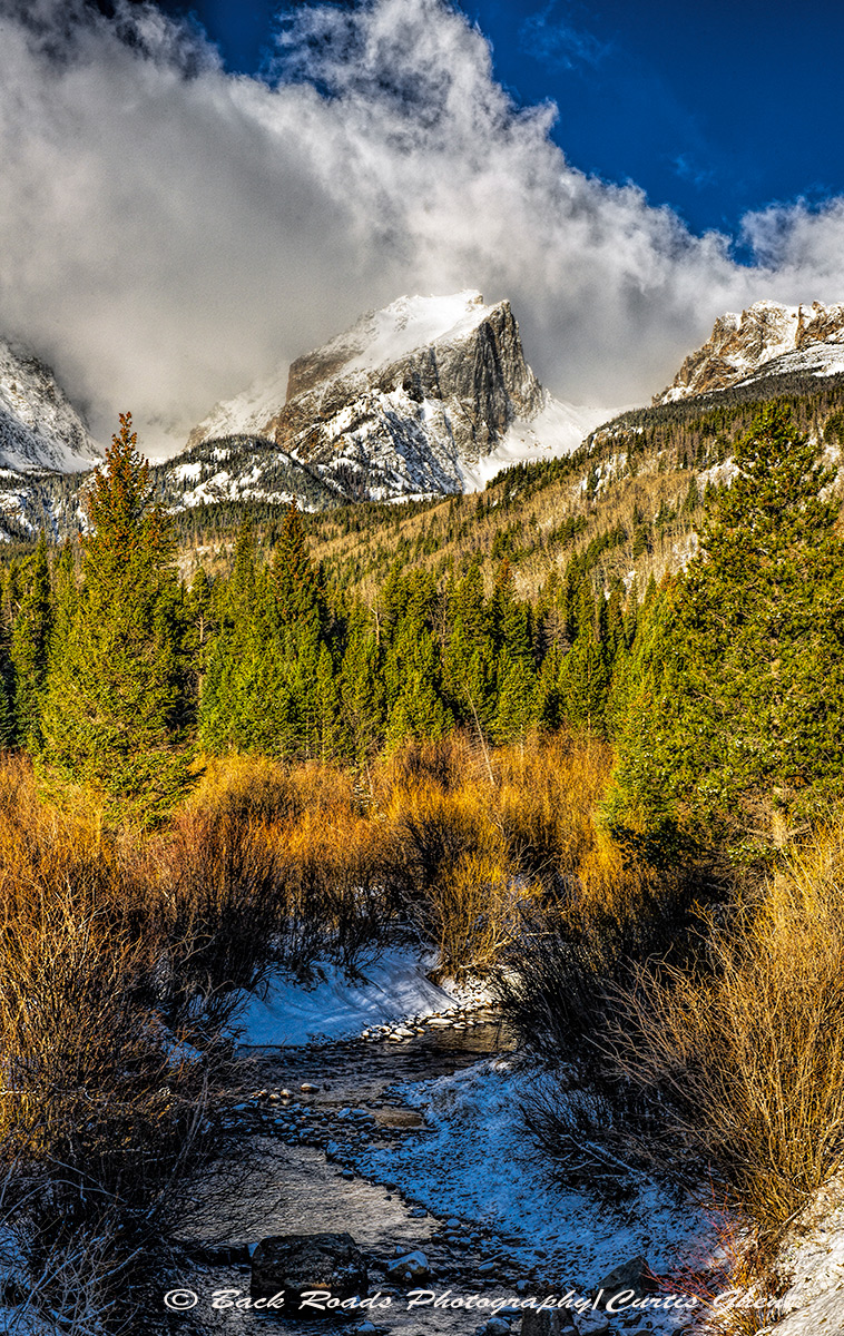 Dramatic storm clouds are building over Hallett Peak for an afternoon rain shower.